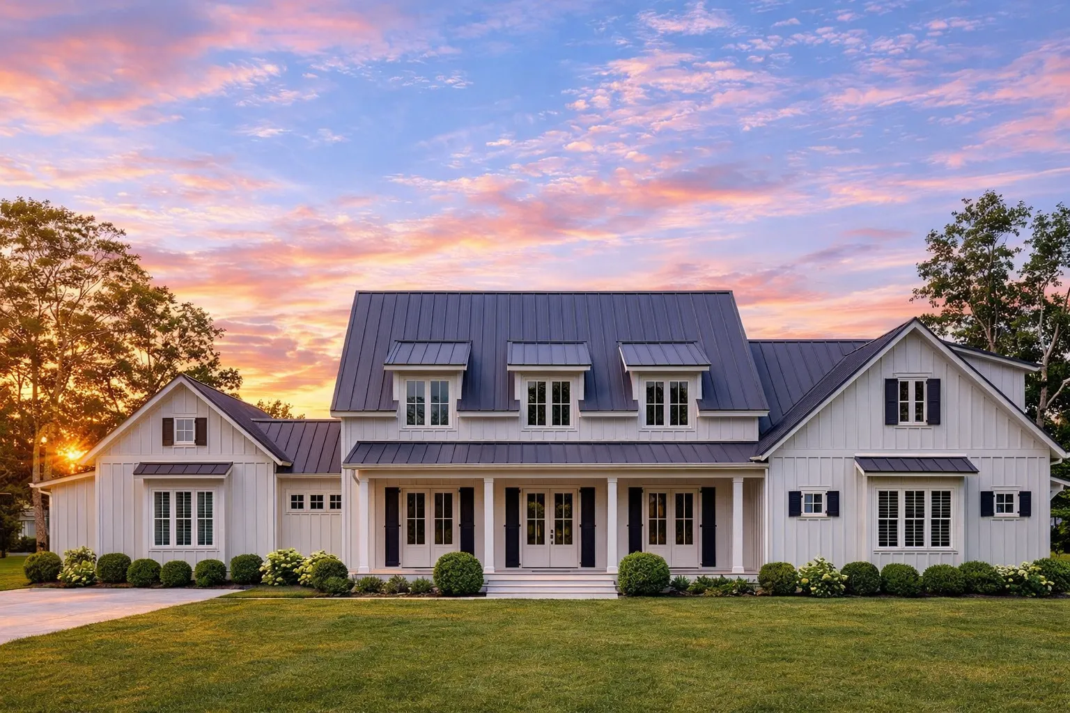 Front elevation of a modern farmhouse style home featuring board and batten siding, stone porch columns, dormer windows, and an attached garage