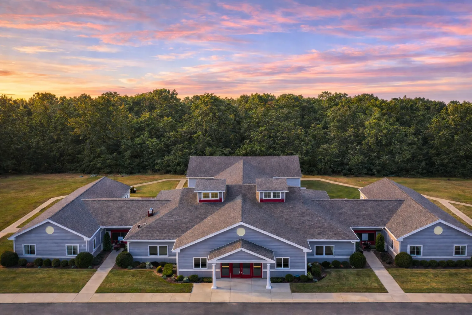 ADU House Plans 5 Front elevation of a Traditional Ranch style home featuring brick and stone exterior, symmetrical wings, central entry, and expansive lawn setting