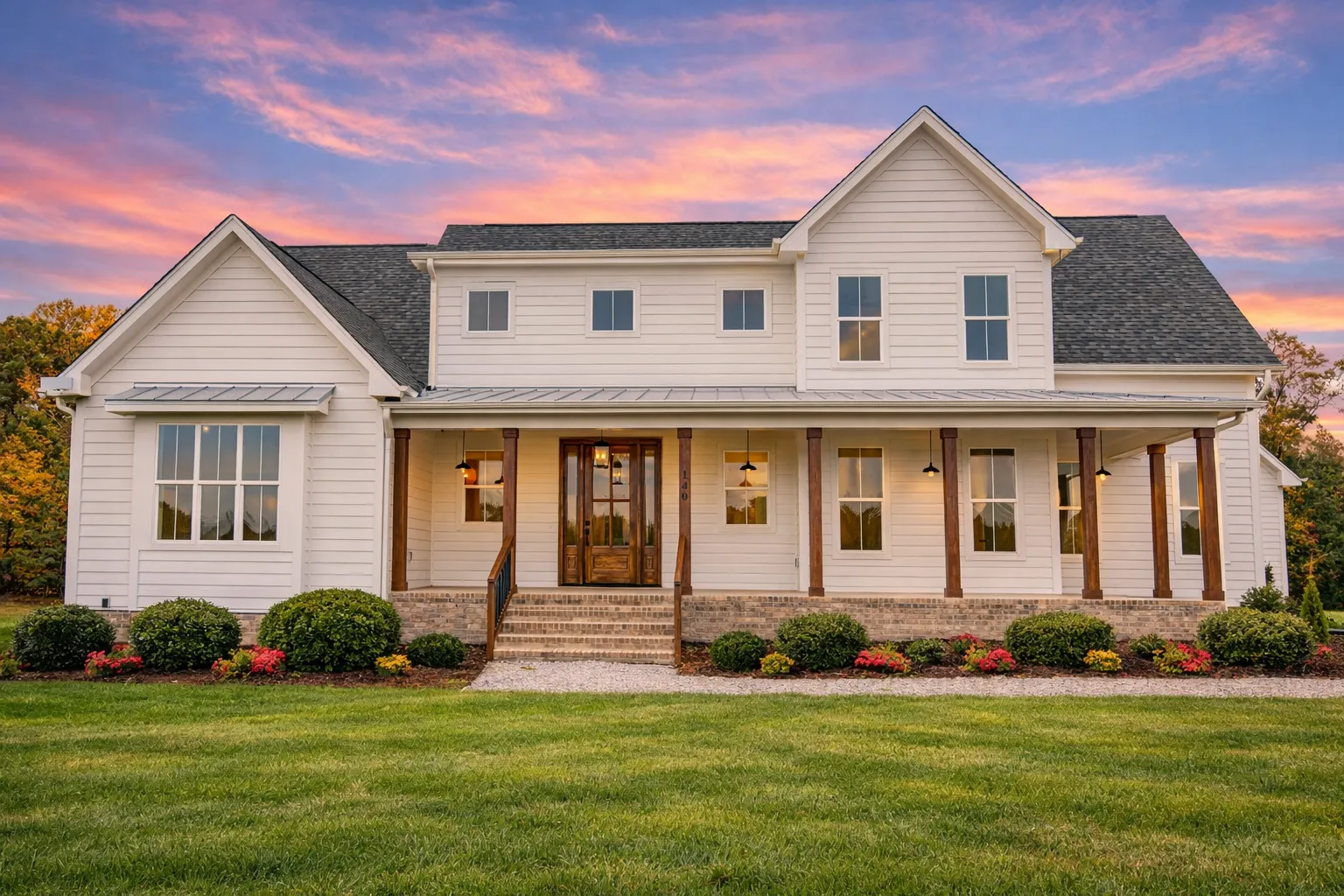 Front elevation of a Modern Farmhouse style home featuring horizontal siding, board and batten accents, gabled rooflines, and a welcoming covered front porch