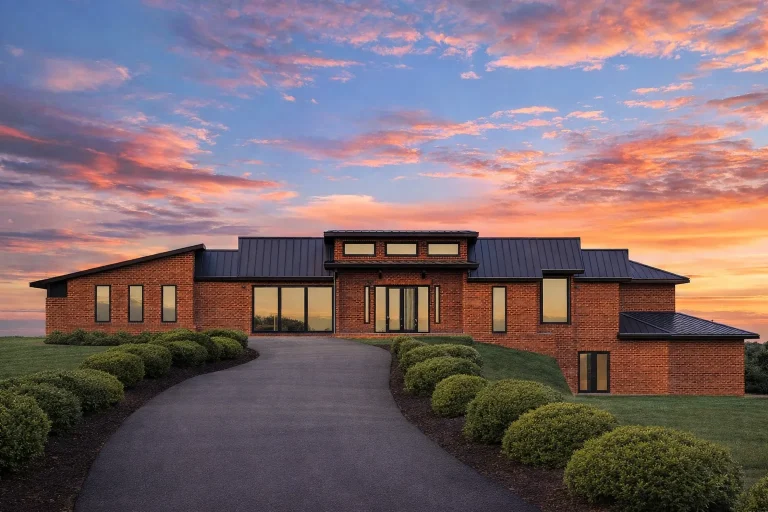 Front elevation of a Transitional Ranch style home featuring brick exterior, board-and-batten siding, low-pitched rooflines, and modern farmhouse detailing