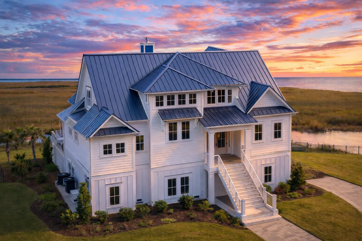 Front elevation of a New American Coastal Traditional style house featuring board and batten siding, shingle accents, stone details, and symmetrical Colonial-inspired architecture
