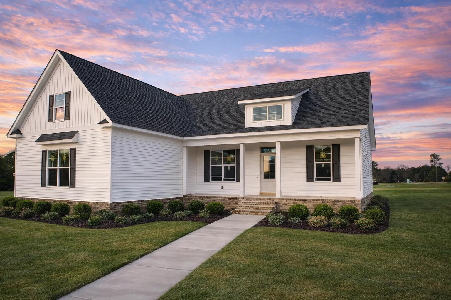 Front view of a Modern Farmhouse Ranch style home featuring board and batten siding, gabled rooflines, brick foundation, and charming curb appeal.