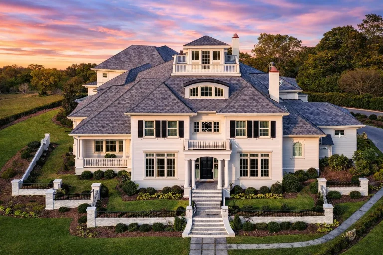 Front elevation of a Colonial Georgian style home with coastal influence, featuring wood shingle siding, symmetrical windows, central entry, and manicured lawn