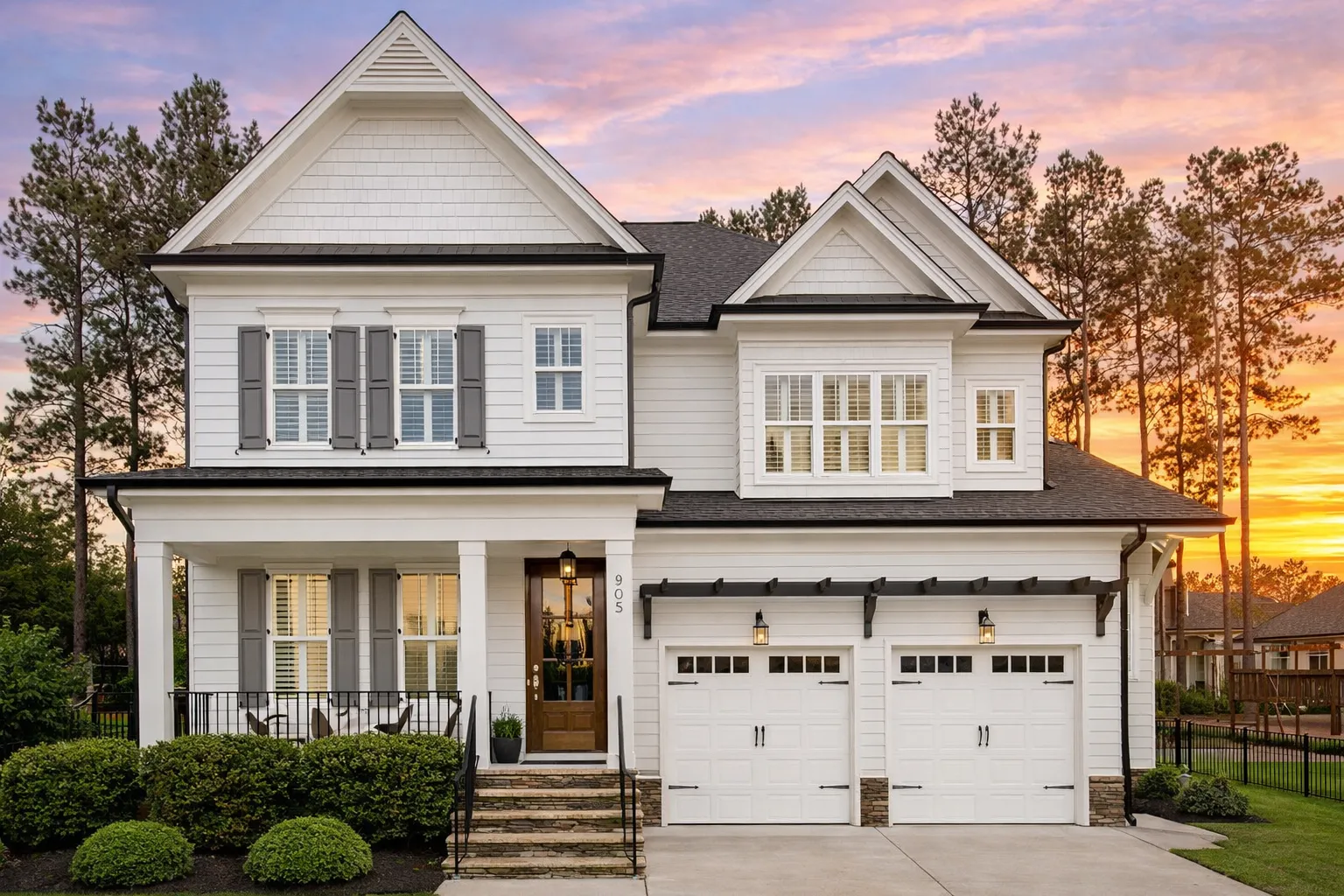 Front elevation of a New American style two-story home with horizontal lap siding, shake accents, covered porch, and attached two-car garage