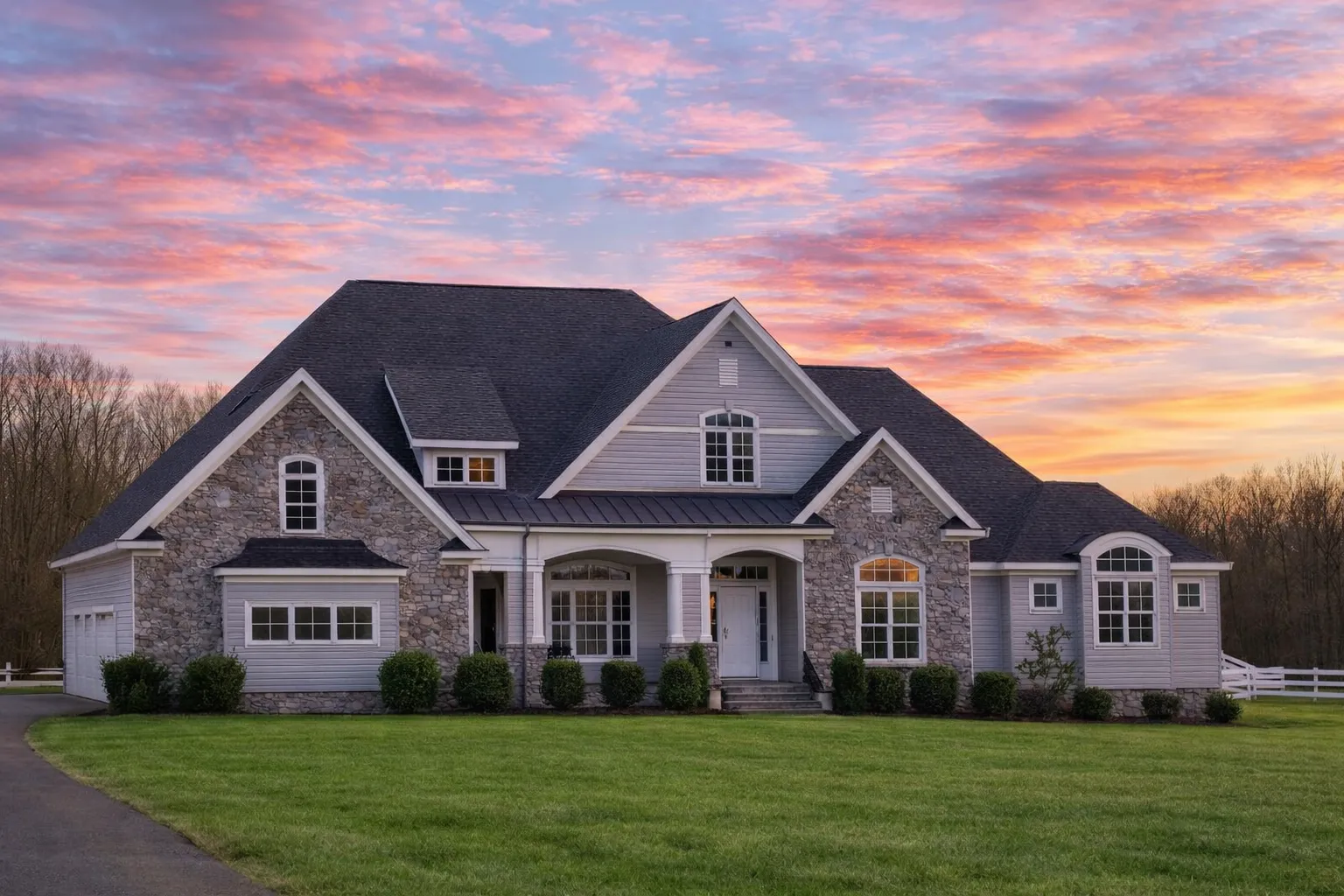 Front elevation of a Modern Farmhouse style home featuring board and batten siding, horizontal lap siding, brick foundation, and symmetrical gabled rooflines