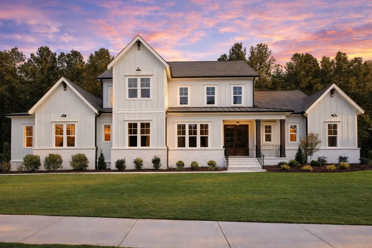Front elevation of a Modern Farmhouse style home featuring board and batten siding, gabled rooflines, large windows, and a welcoming covered front porch