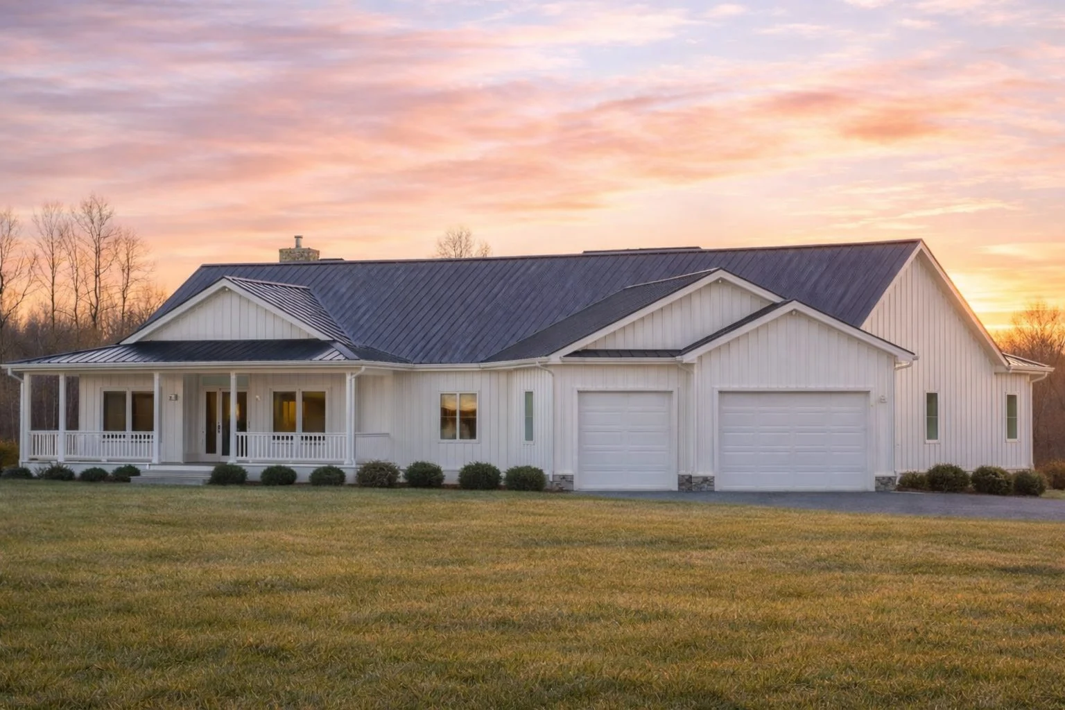 Front elevation of a modern farmhouse ranch style home with horizontal siding, dark metal roof, covered front porch, and attached garage