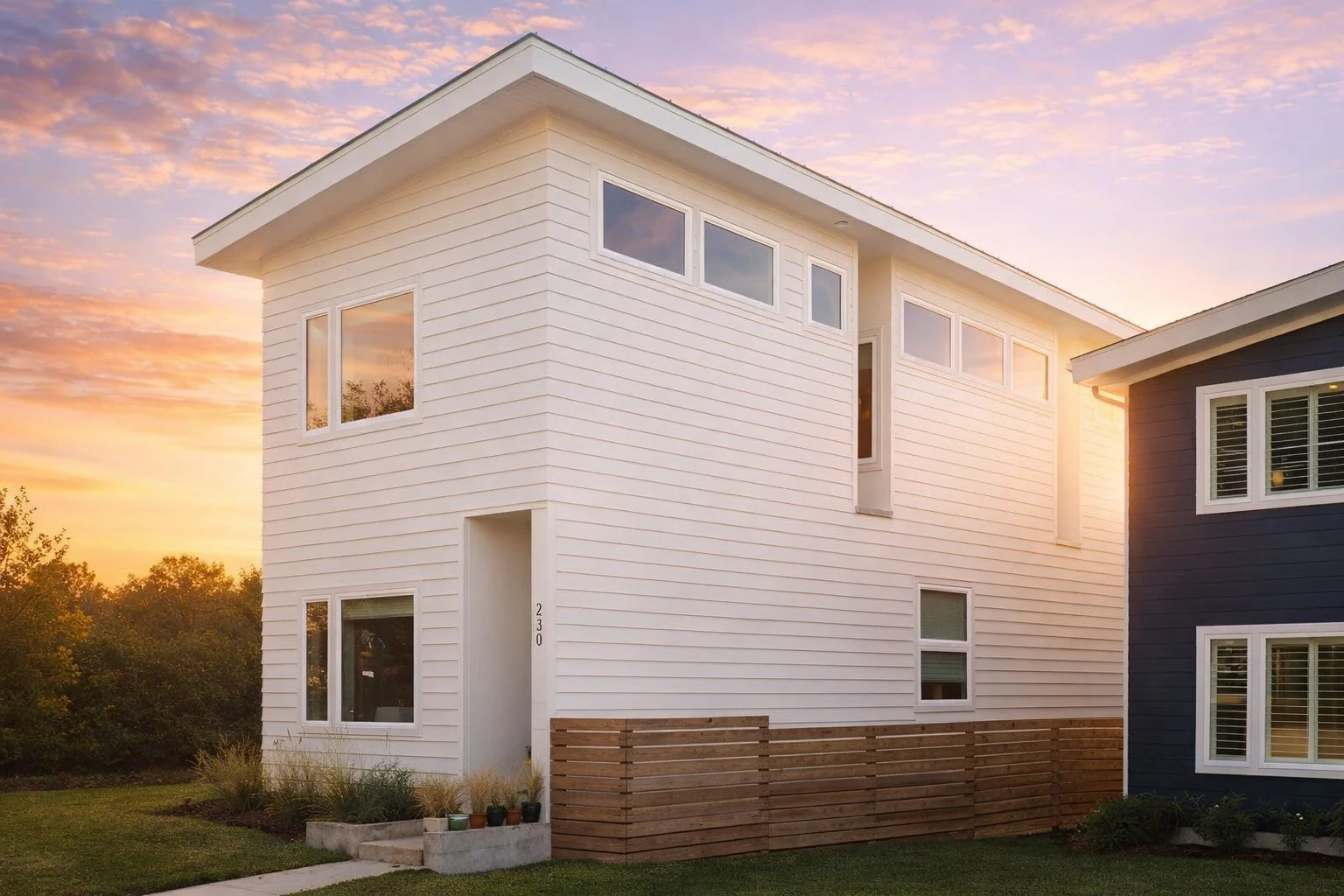 Front exterior view of a contemporary modern narrow lot home with horizontal lap siding, asymmetrical roofline, and large black-framed windows