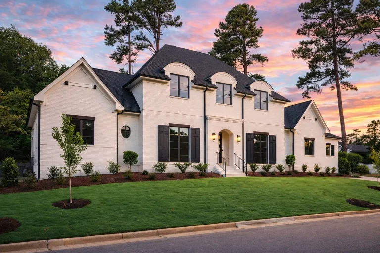 House Plans 7 Front elevation of a Modern Farmhouse style home featuring white painted brick exterior, black shutters, steep gabled rooflines, and symmetrical Southern-inspired design