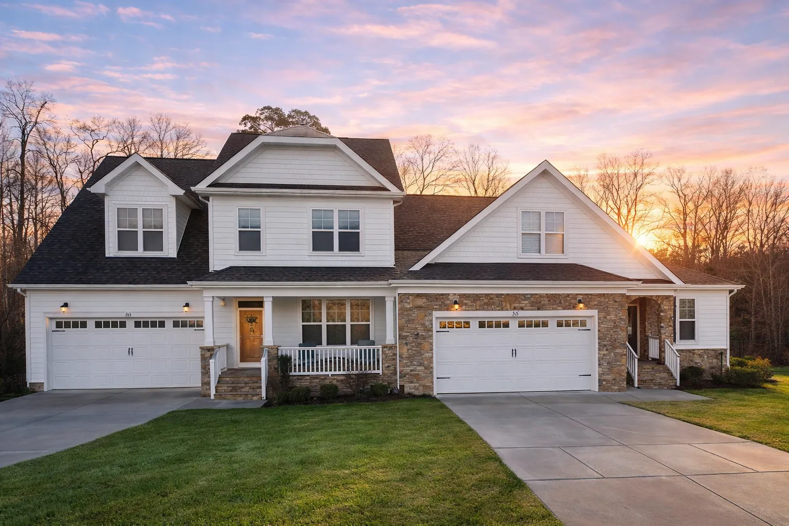 Front view of a Modern Farmhouse and Craftsman style home featuring board and batten siding, stone accents, and triple garage design