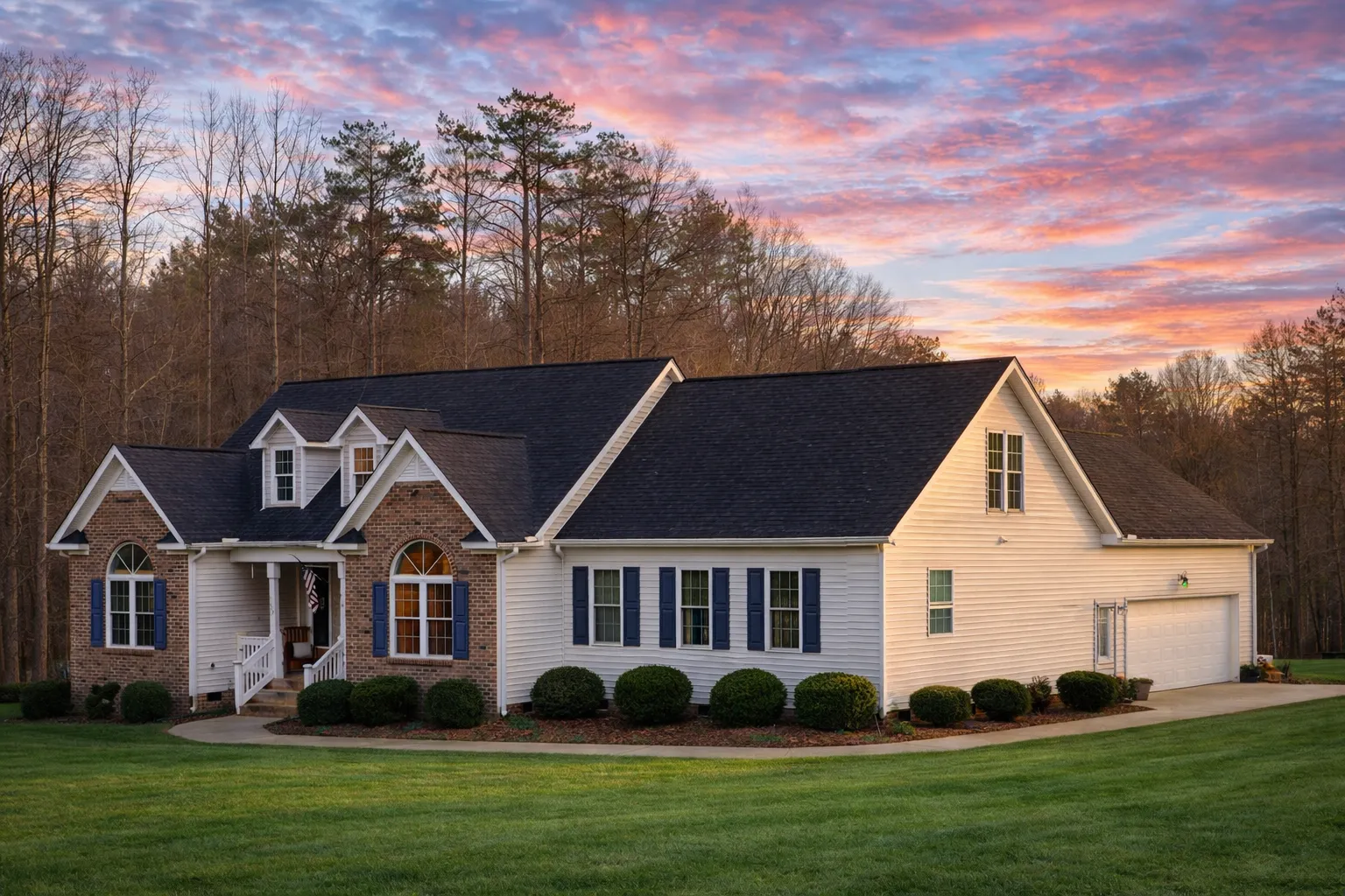 Front elevation of a Traditional Colonial style home featuring a brick façade, horizontal siding, dormers, and symmetrical architectural detailing