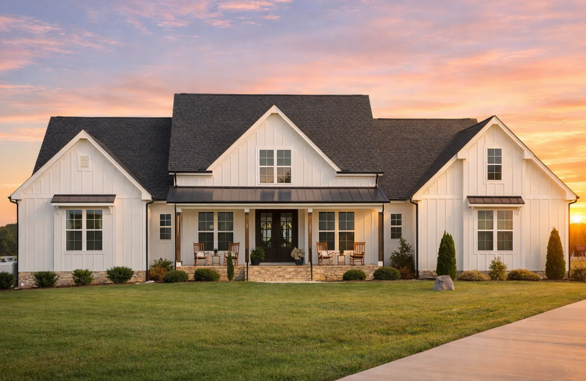 Front elevation of a Modern Farmhouse style home featuring white board and batten siding, symmetrical gables, black windows, and a welcoming covered front porch
