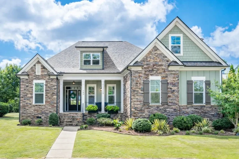 Front elevation of a New American style house featuring stone veneer, board-and-batten siding, gabled rooflines, and symmetrical modern traditional detailing