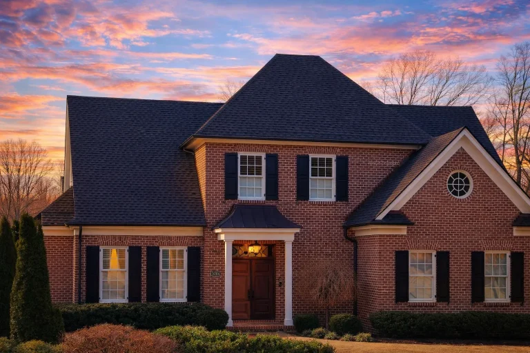 Front elevation of Traditional Colonial style home with full brick exterior, black shutters, gabled roof, and centered entry