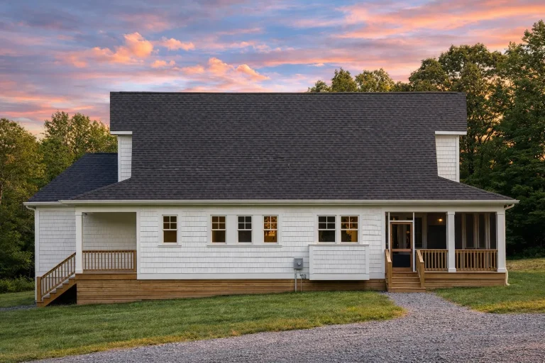 Front elevation of a Coastal Cottage farmhouse-style home with lap siding, board-and-batten gables, brick foundation, and covered front porch