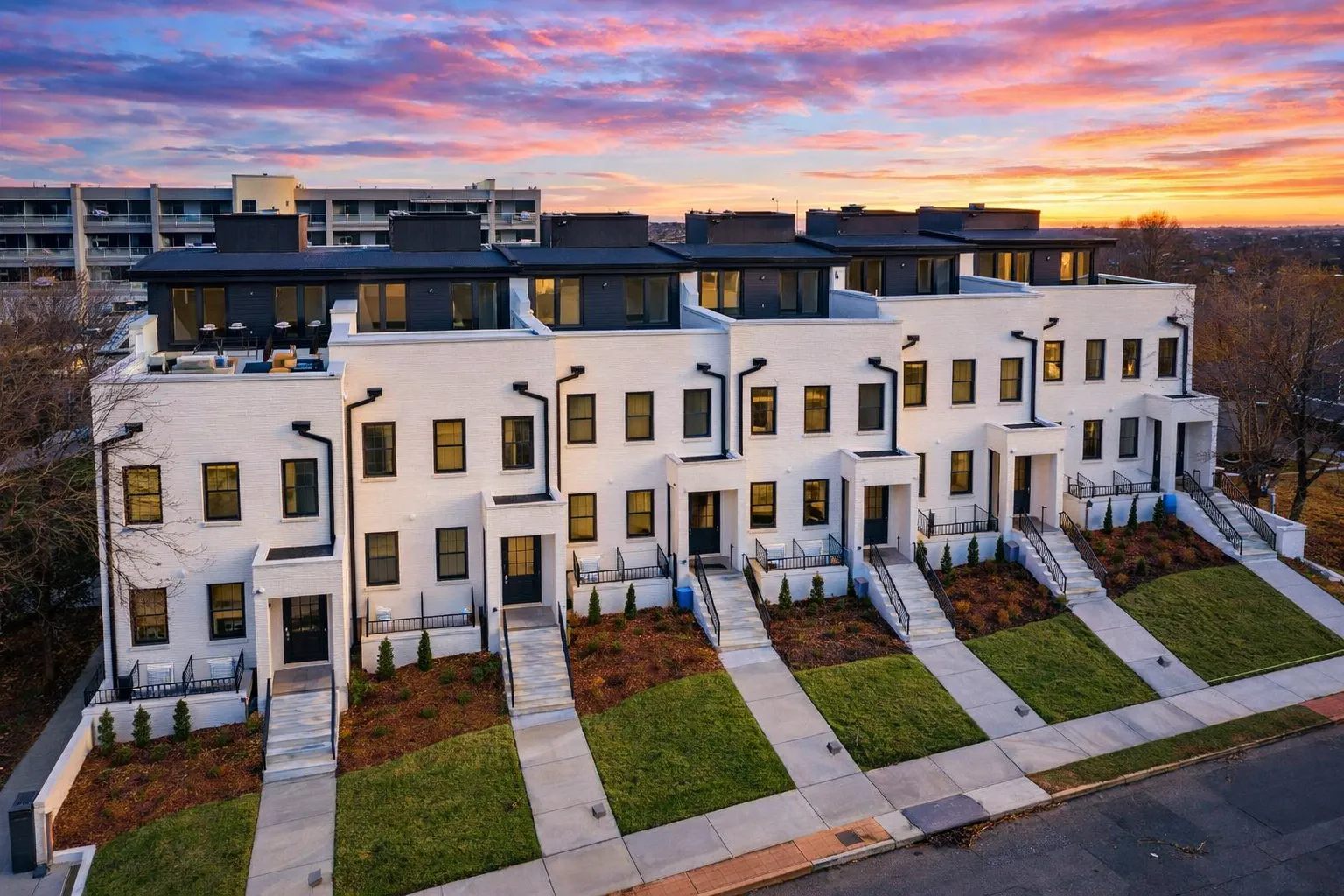 Front elevation of Georgian Neoclassical style multi-unit townhome featuring full brick exterior, tall windows, and symmetrical design details
