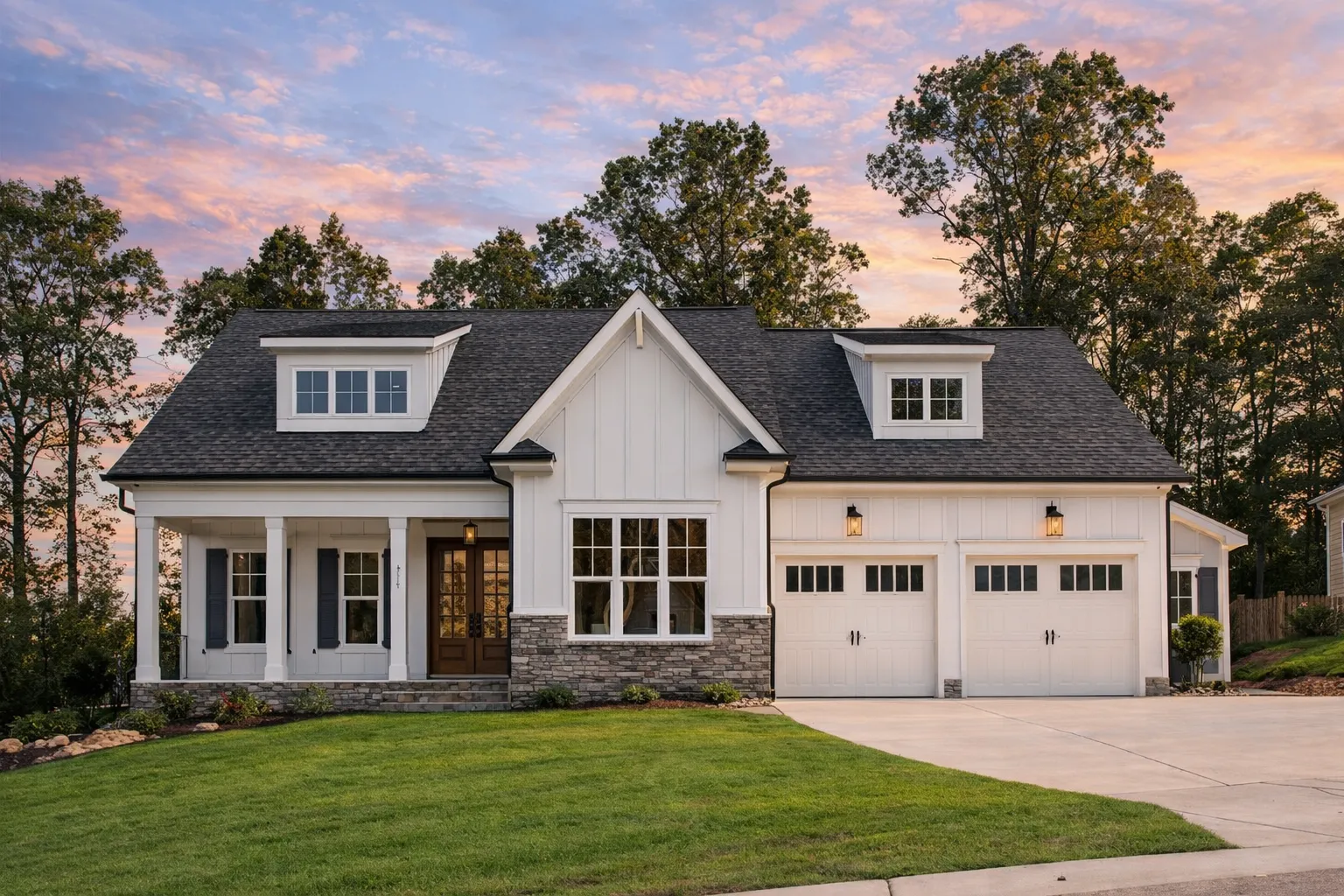 Front elevation of a Modern Farmhouse style home featuring board and batten siding, stone accents, gabled rooflines, and a covered front porch