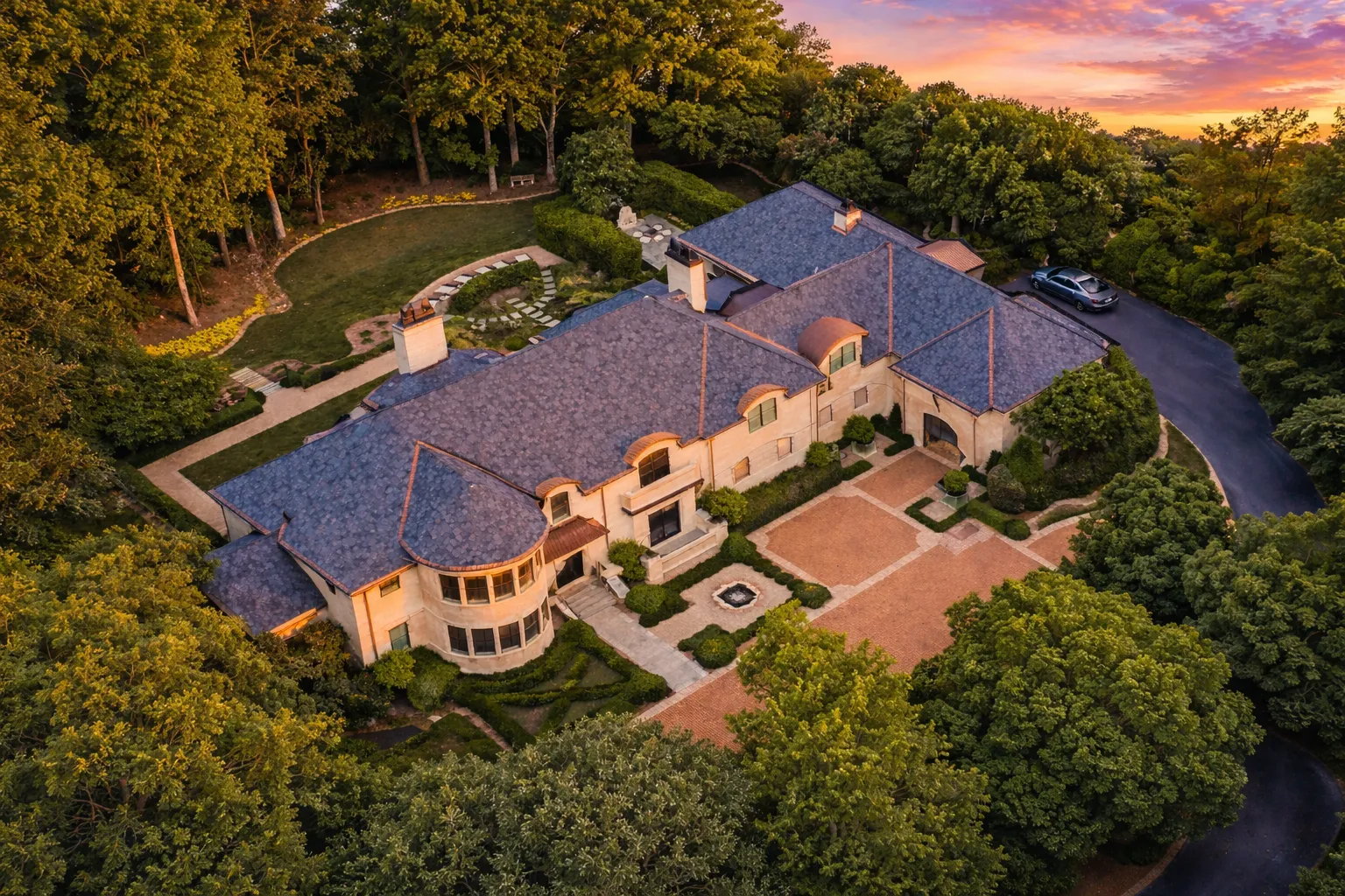 Front elevation of a French Provincial style luxury home featuring brick exterior, arched windows, and elegant European detailing