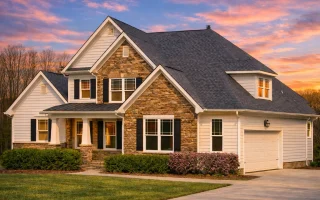Front elevation of a New American Craftsman style home with stone accents, horizontal siding, gabled rooflines, and a covered front porch