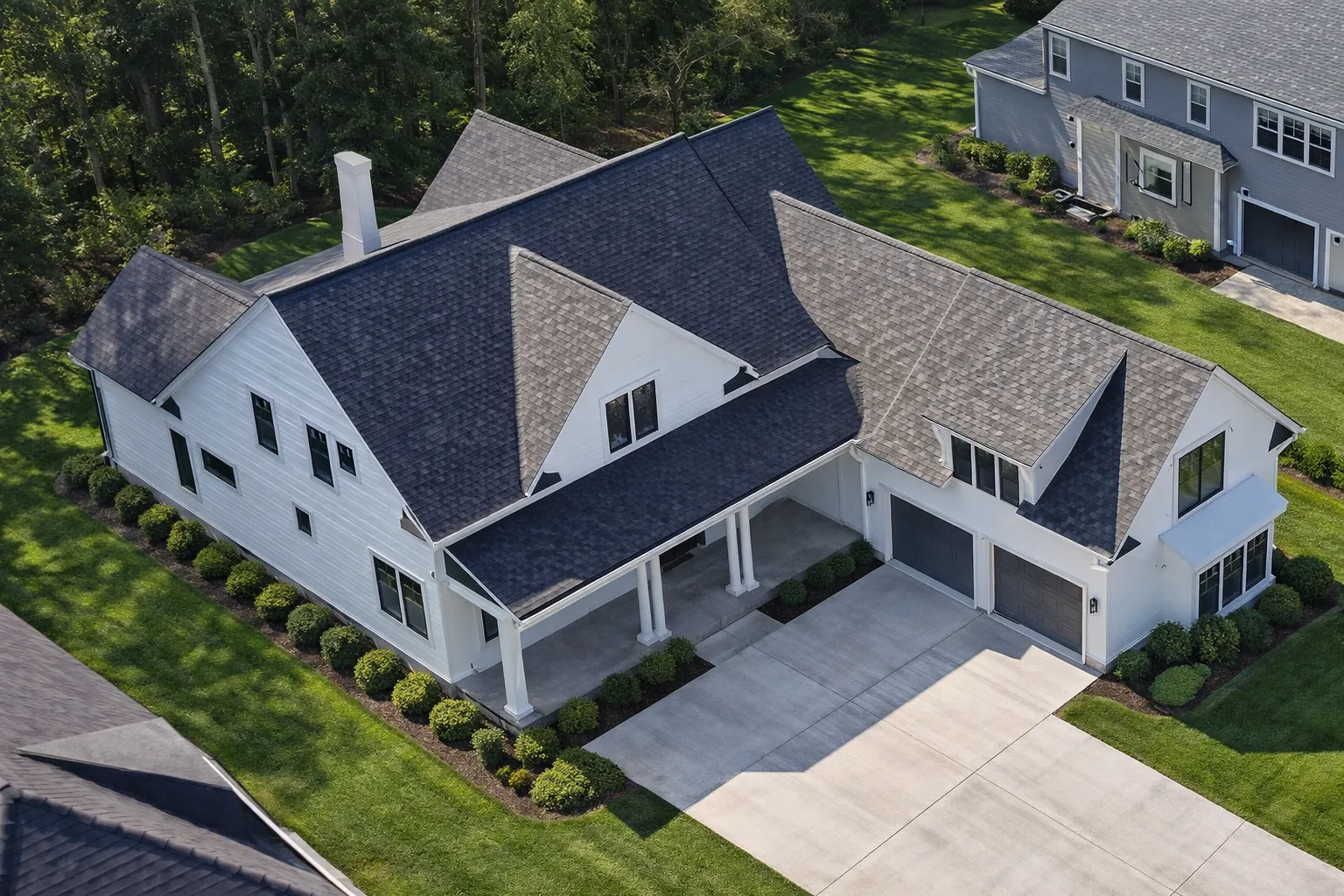 Front elevation of a Colonial Traditional style home with white lap siding, black shutters, stone foundation, and covered front porch