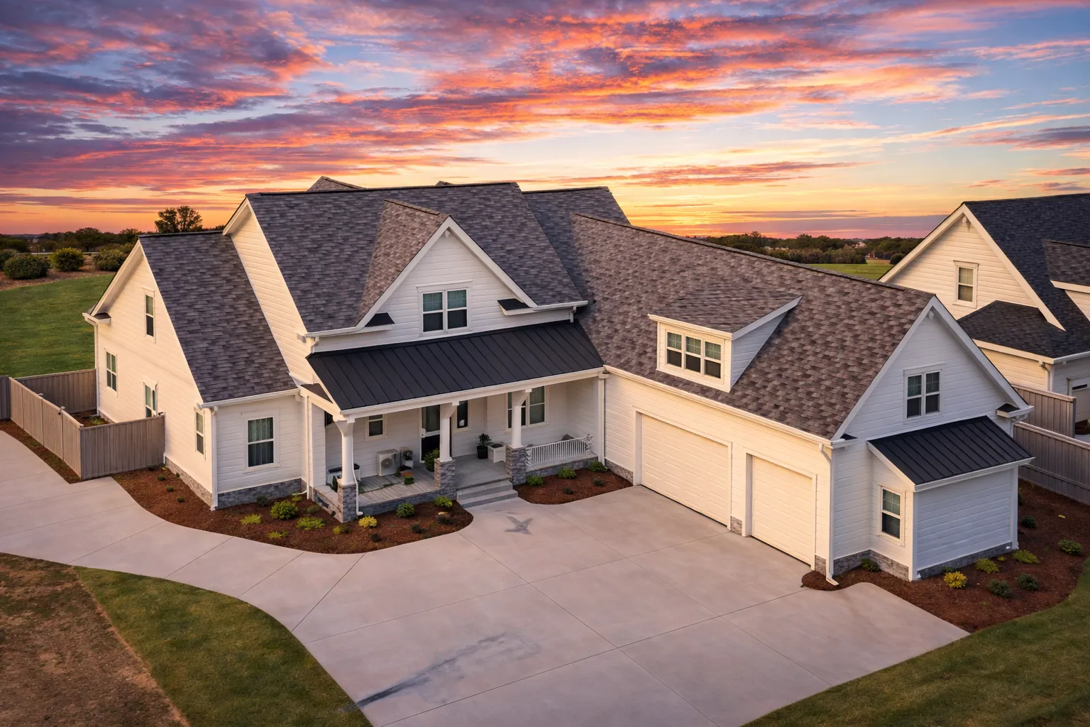 Front elevation of a Modern Farmhouse style home featuring white board and batten siding, black metal porch roof, brick foundation, and symmetrical gabled architecture