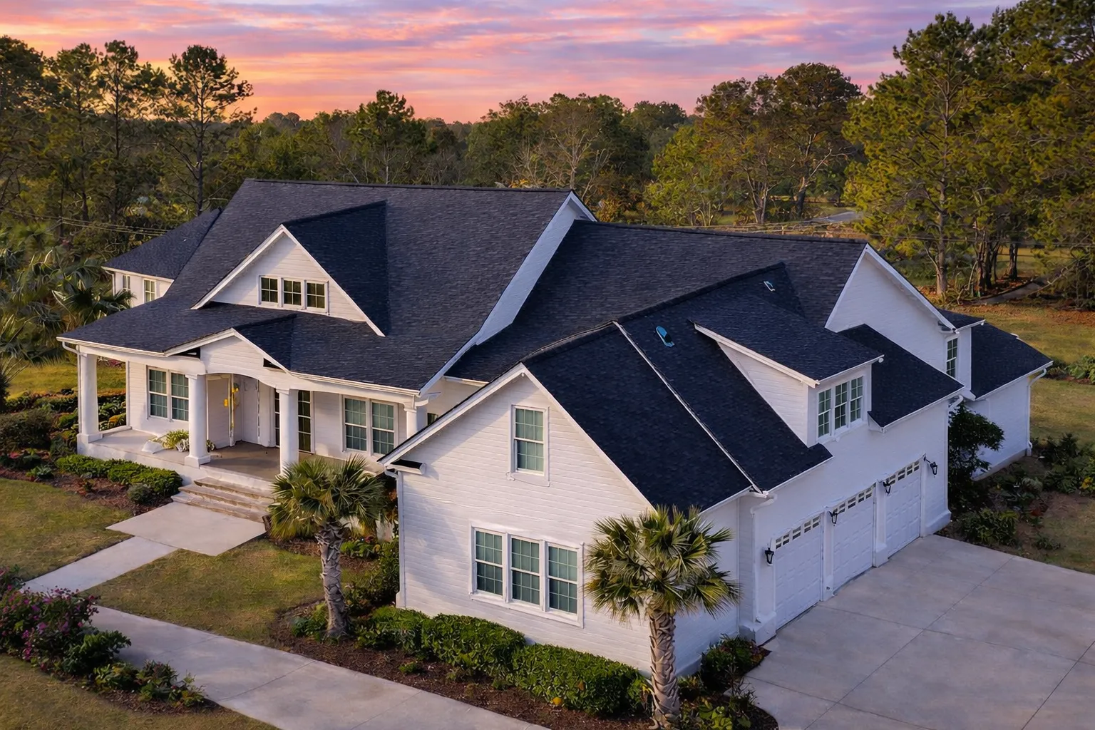 Front elevation of a New American modern traditional house with stone accents, white siding, symmetrical windows, and a covered entry porch