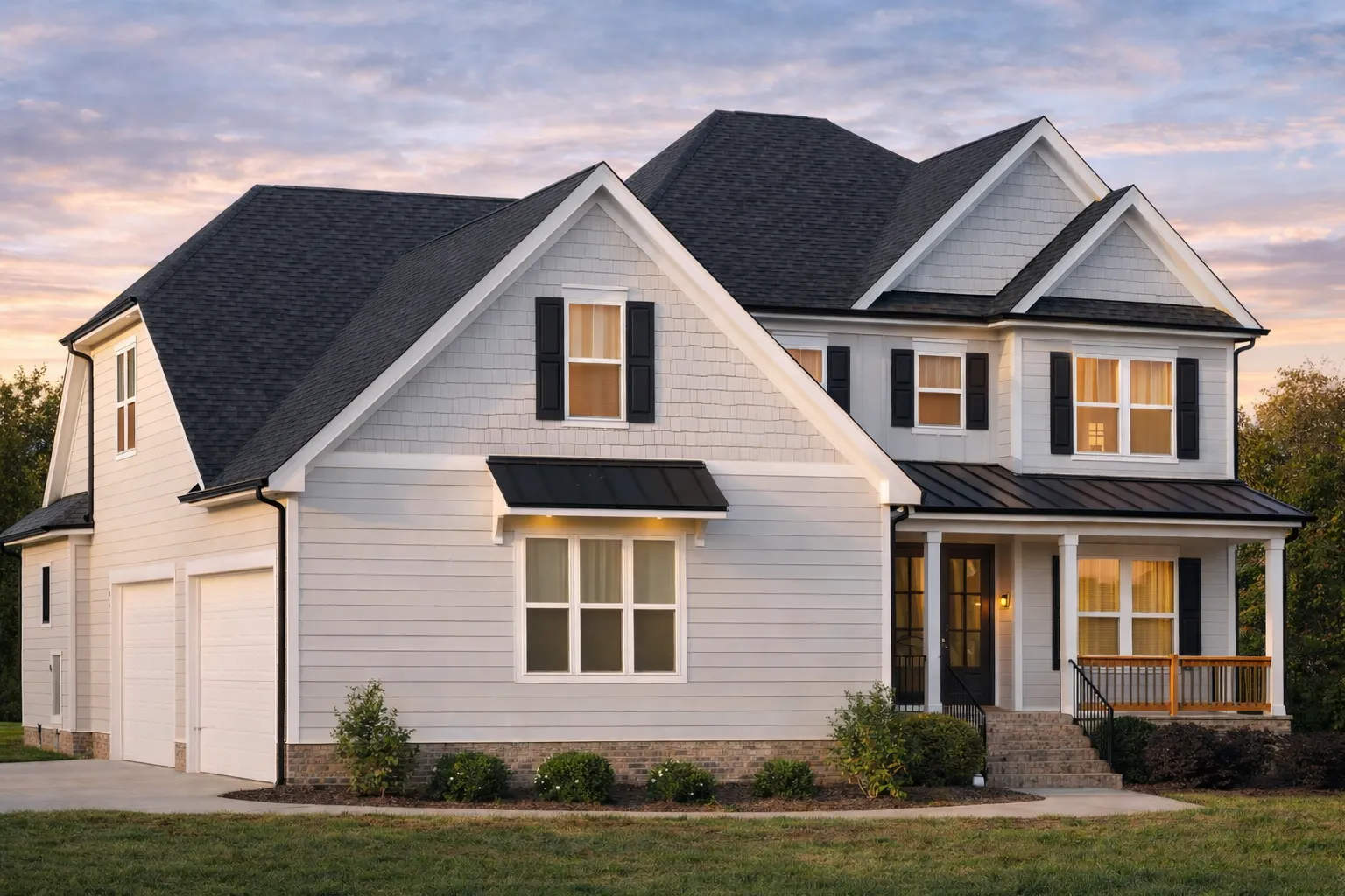 Front elevation of Traditional Colonial home with horizontal lap siding, stone veneer base, symmetrical windows, and gabled roof