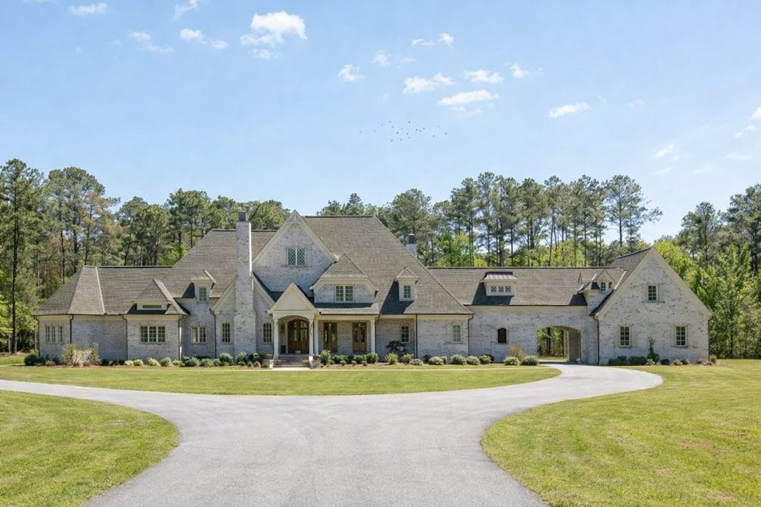 Front elevation of a Traditional New American suburban house featuring stone entry, painted brick accents, lap siding, and a symmetrical roofline