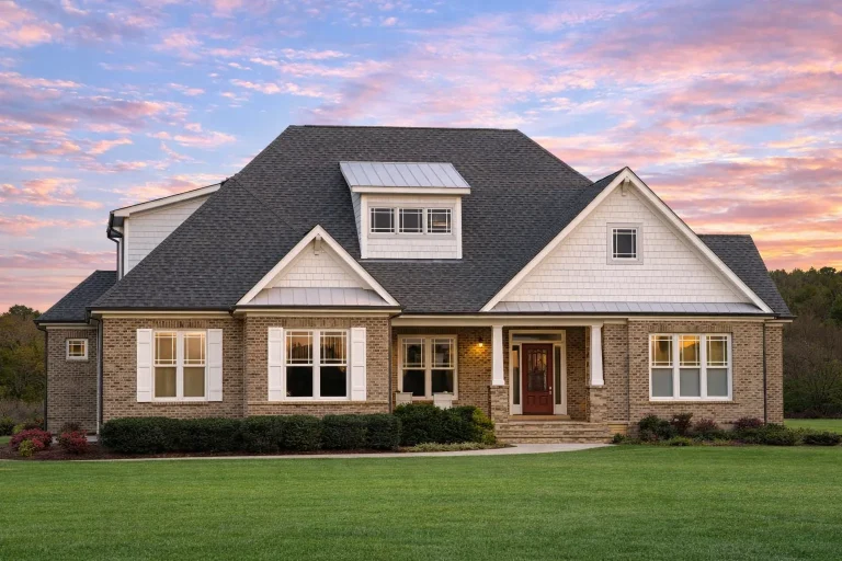 Front elevation of a New American Traditional style house featuring horizontal siding, stone accents, symmetrical windows, and a welcoming covered entry