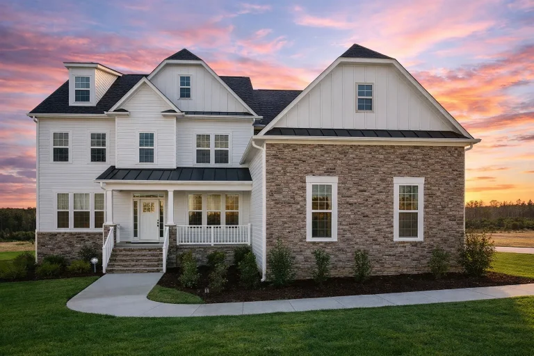 Front elevation of a Traditional Colonial style house with horizontal siding, stone accents, symmetrical façade, and New American rooflines