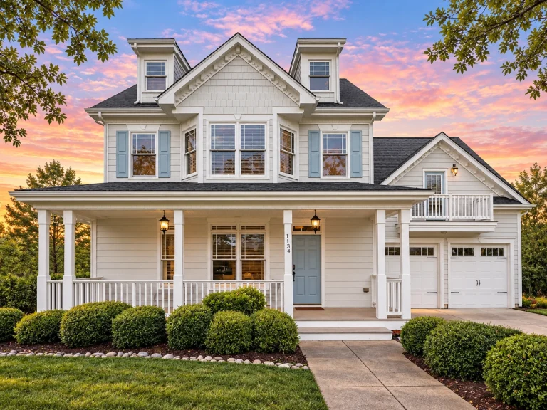 Front elevation of a Neo-Colonial / Traditional Colonial home with horizontal lap siding, stone veneer accents, black shutters, dormers, and a welcoming covered porch