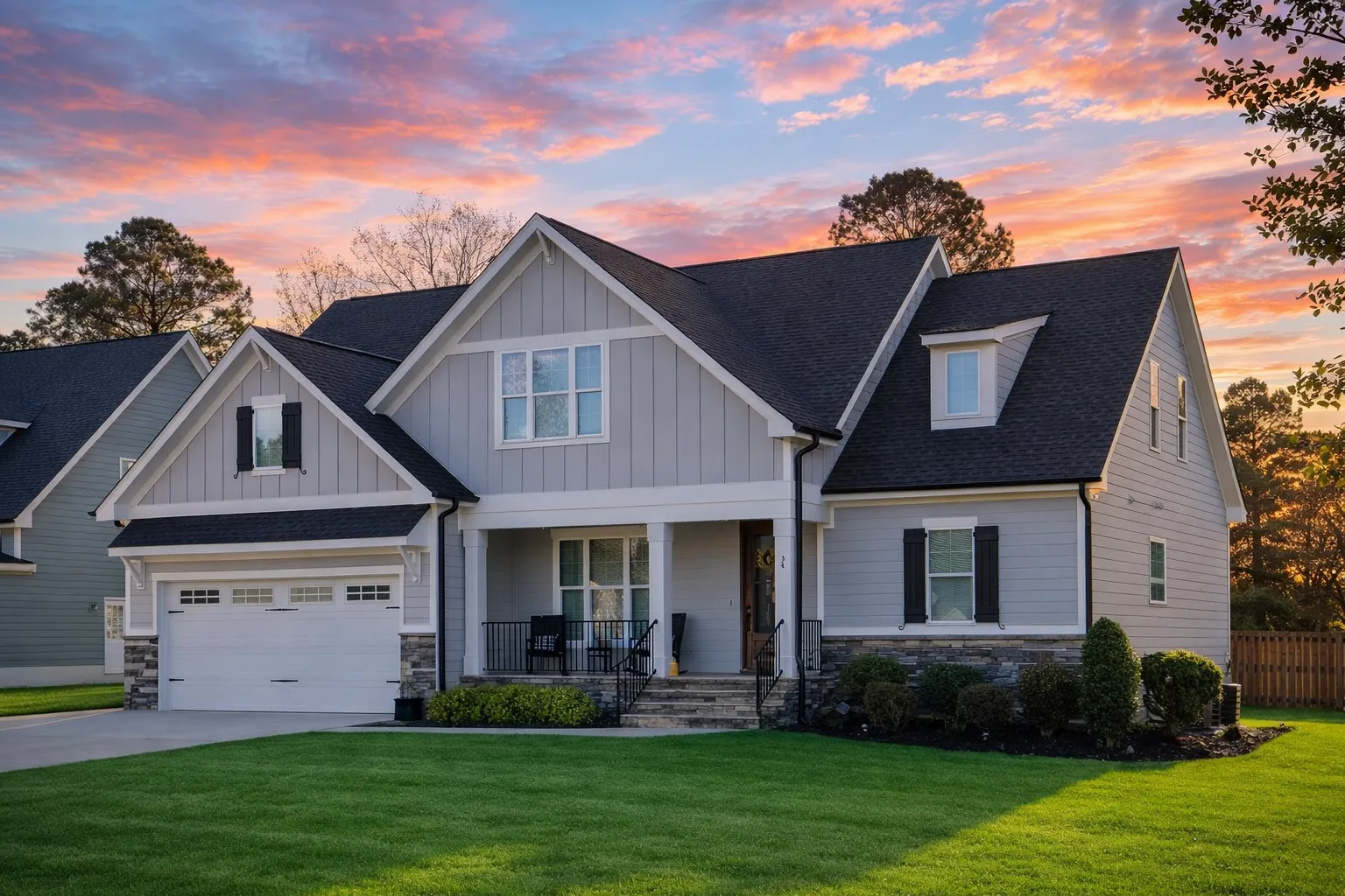 Front elevation of a Modern Farmhouse home with brick exterior, board and batten gables, covered porch, and two-car garage