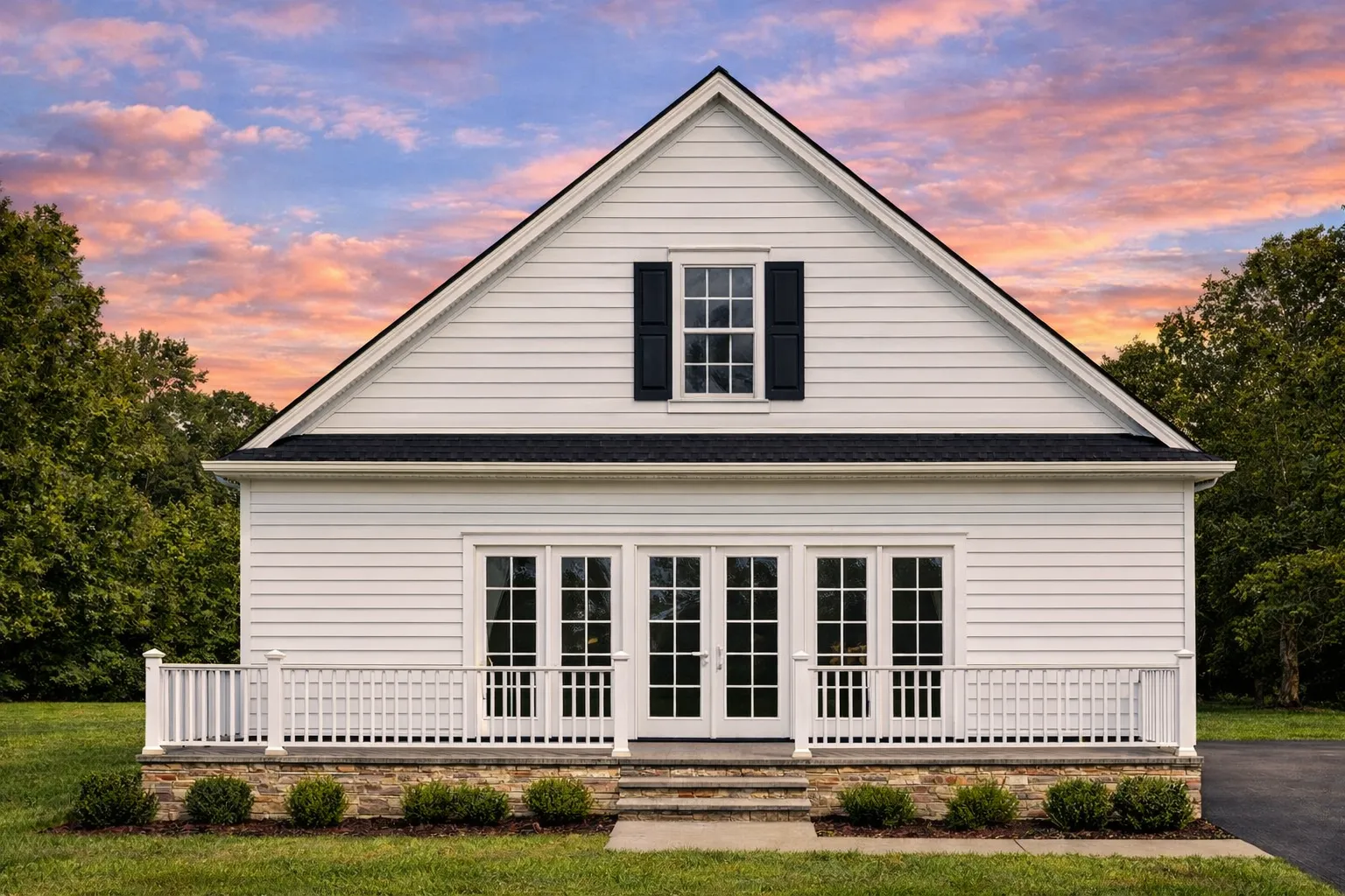 Rear exterior view of an American Cottage style home with coastal influences, raised foundation, horizontal siding, and full-width elevated deck