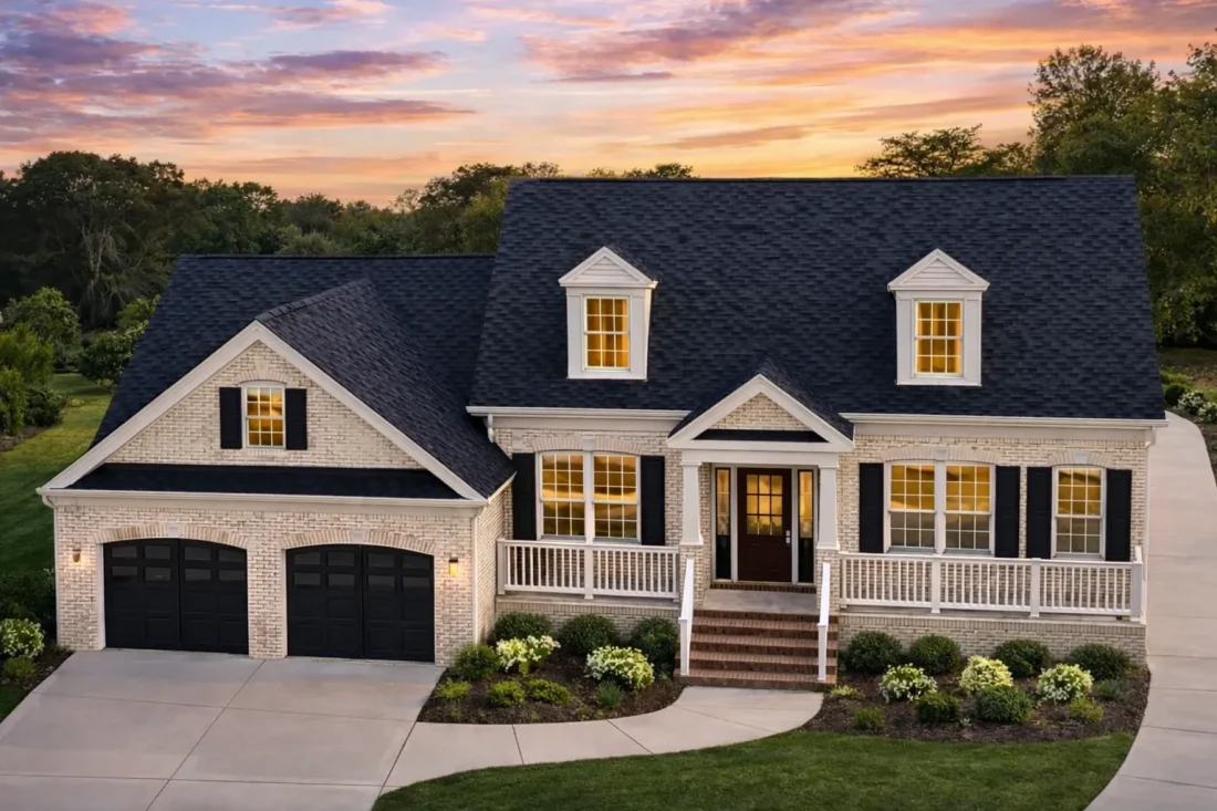 Front elevation of a Cape Cod style home with horizontal siding, brick foundation, dormer windows, and a welcoming covered front porch