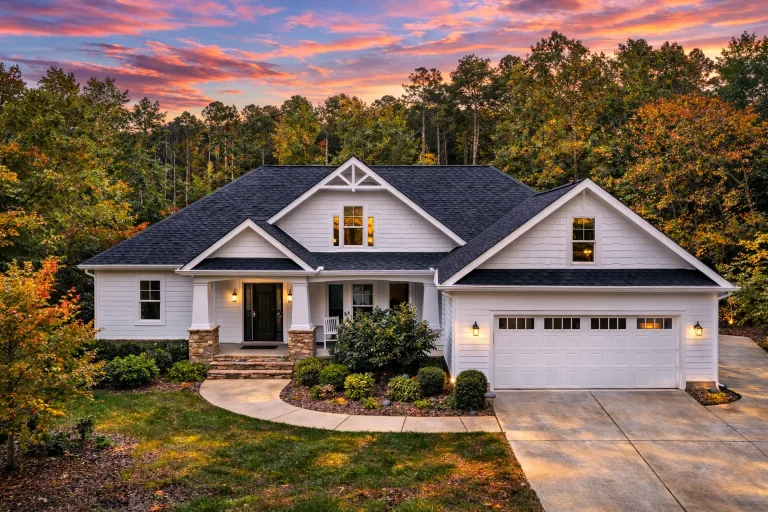 Front elevation of a Traditional Colonial style home with horizontal clapboard siding, symmetrical facade, shuttered windows, and central entry porch