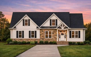 Front view of Craftsman Traditional style home featuring stone veneer, horizontal siding, and shingle accents in gables with covered porch entry