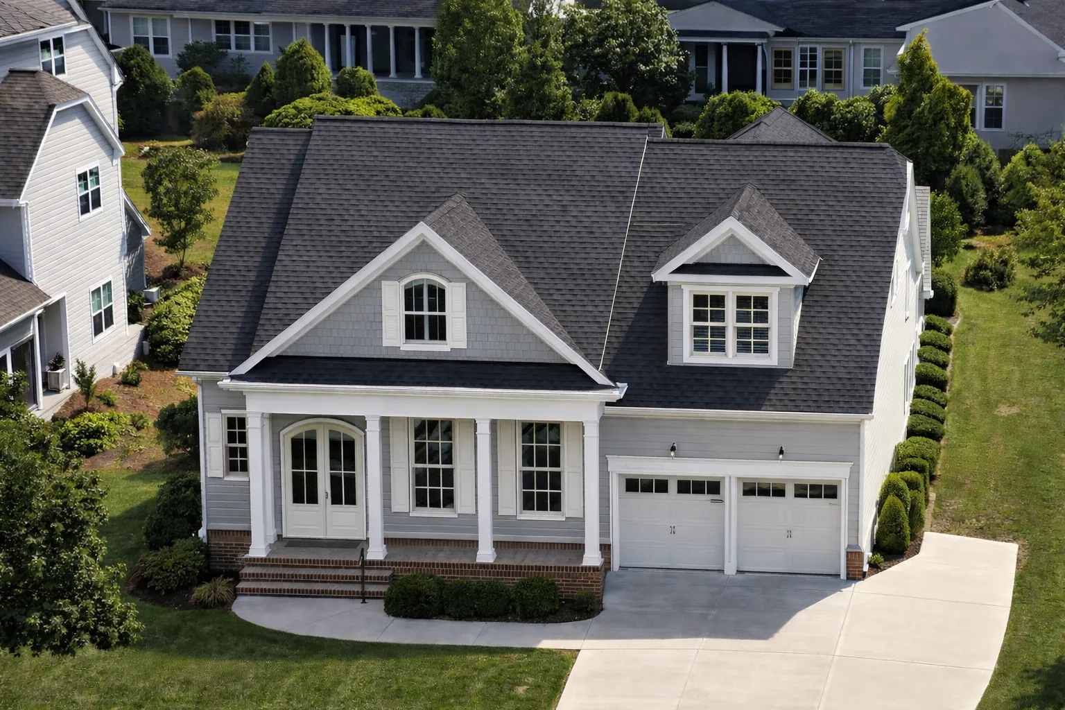 Front elevation of a New American Colonial style home with horizontal siding, brick foundation, dormer windows, and covered front porch