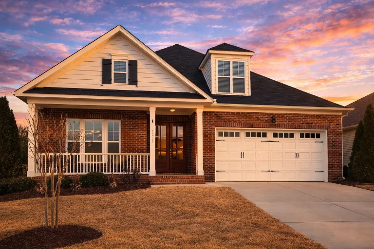 Traditional ranch house front elevation with brick exterior, white trim, porch, dormer, and two-car garage at 4pm daylight—enhanced realism and depth