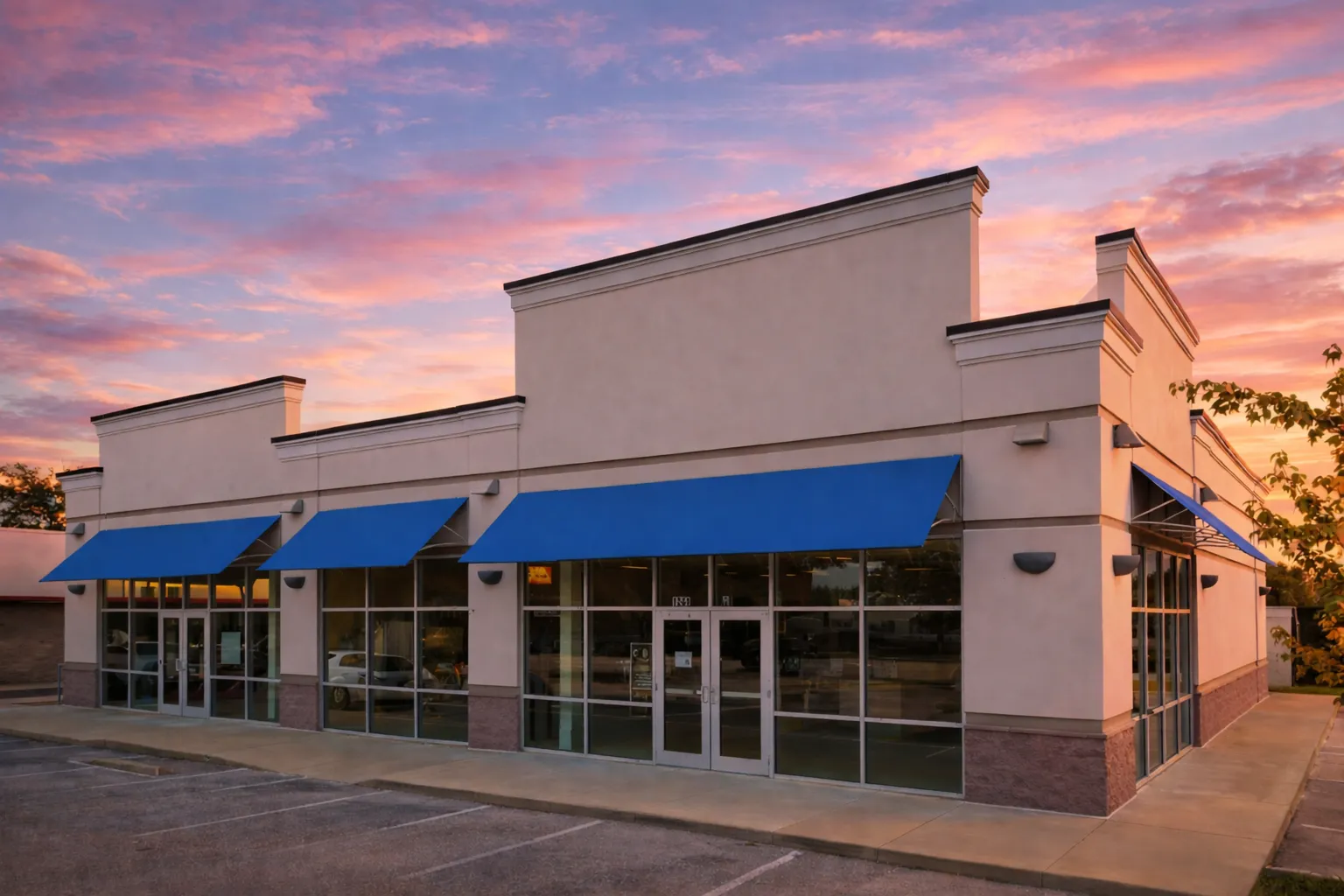 House Plans with Balcony or Deck 23 Front exterior view of a contemporary commercial building featuring stucco walls, horizontal brick accent bands, stone base, and glass entry doors