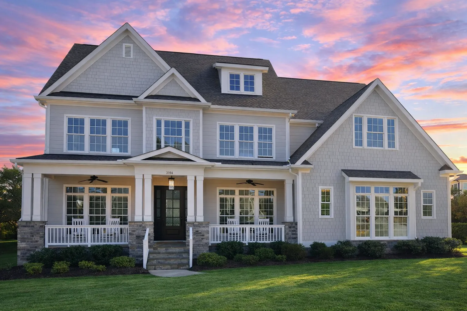 Front elevation of a New American Modern Traditional house featuring horizontal siding, board and batten accents, classic gables, and an inviting covered porch