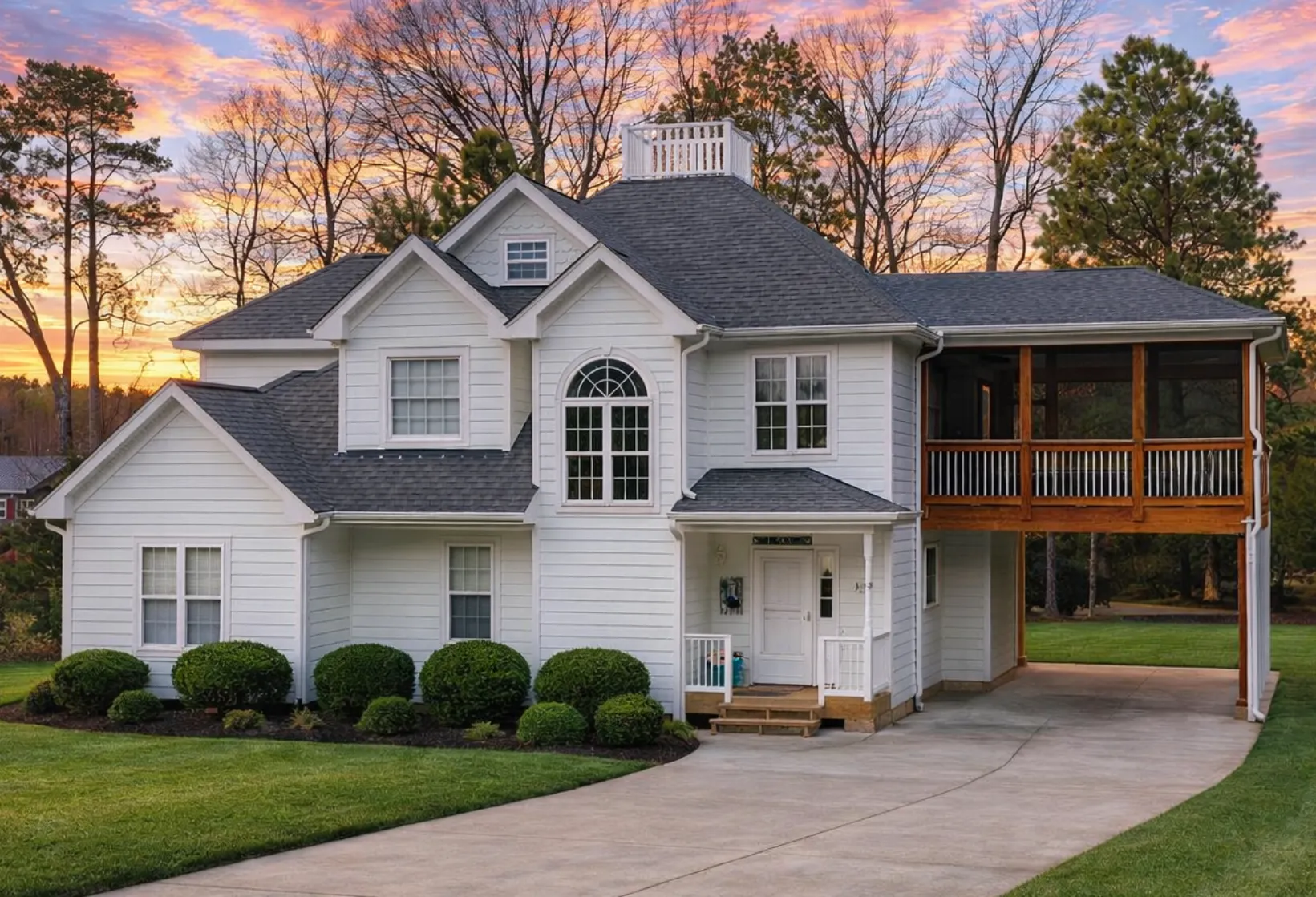 Front elevation of a Modern Farmhouse home featuring board-and-batten siding, dark roofing, traditional windows, and a large elevated deck
