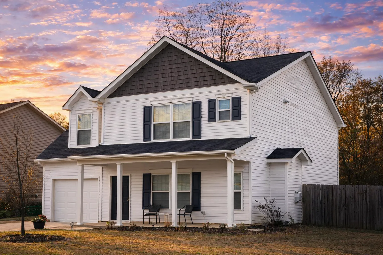 Front elevation of a New American style house with horizontal siding, shingle gable accents, covered front porch, and attached garage