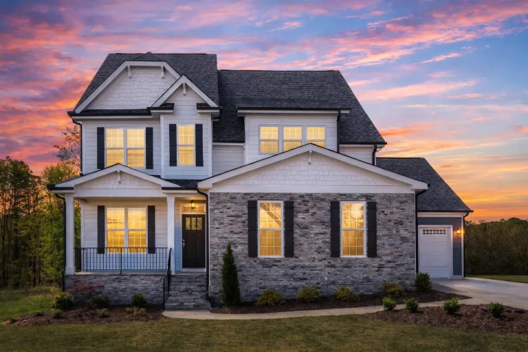 Front elevation of a Traditional Colonial style home with Craftsman influences, featuring blue horizontal lap siding, stone veneer accents, and symmetrical windows.