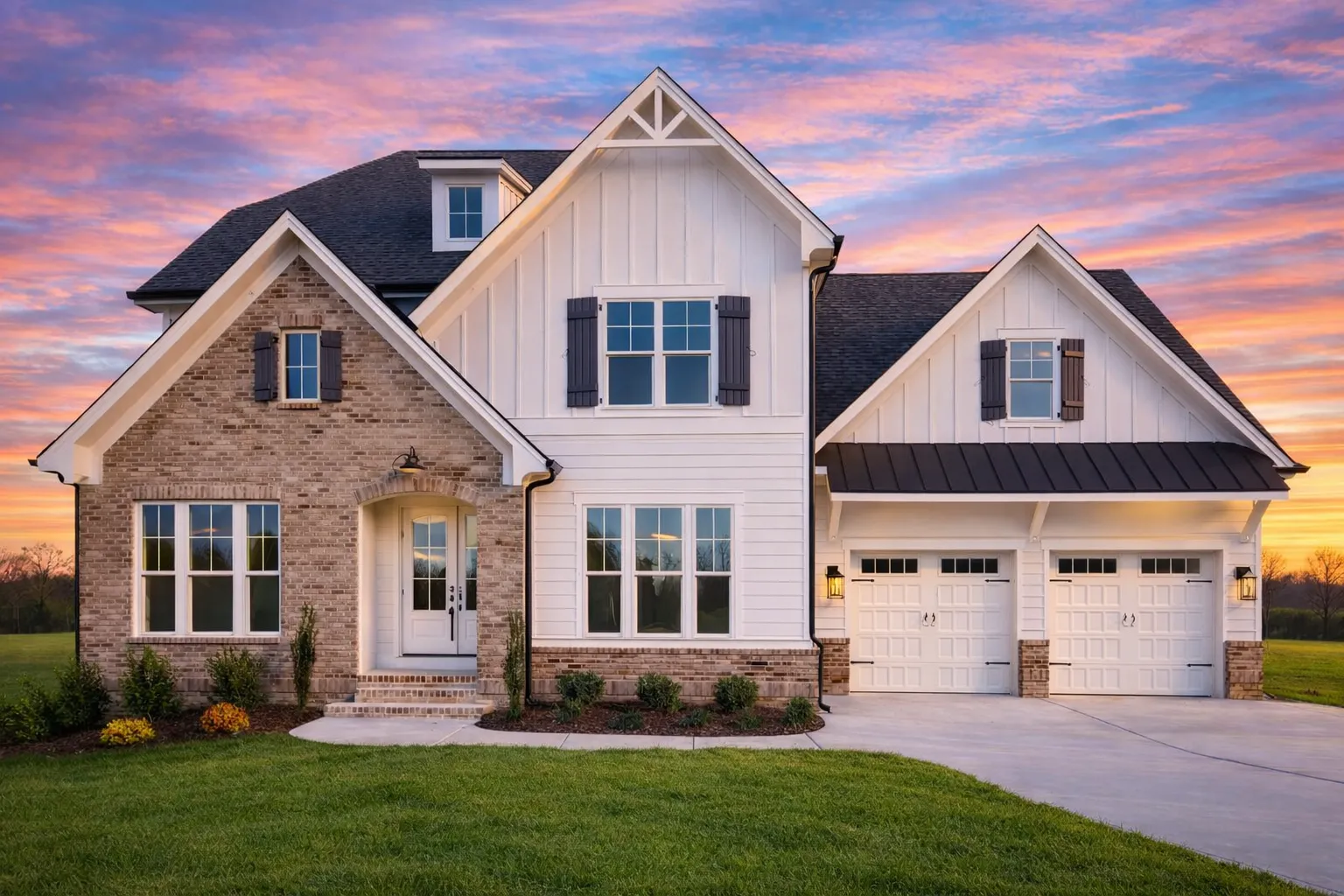 Front exterior of a Modern Farmhouse style home featuring board and batten siding, stone accents, gabled rooflines, and an attached garage