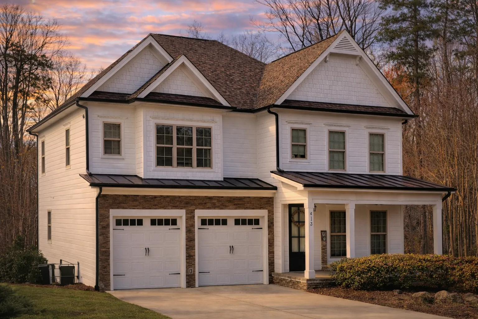 Front exterior of New American Modern Traditional house with horizontal lap siding, gabled rooflines, double garage, and covered front porch