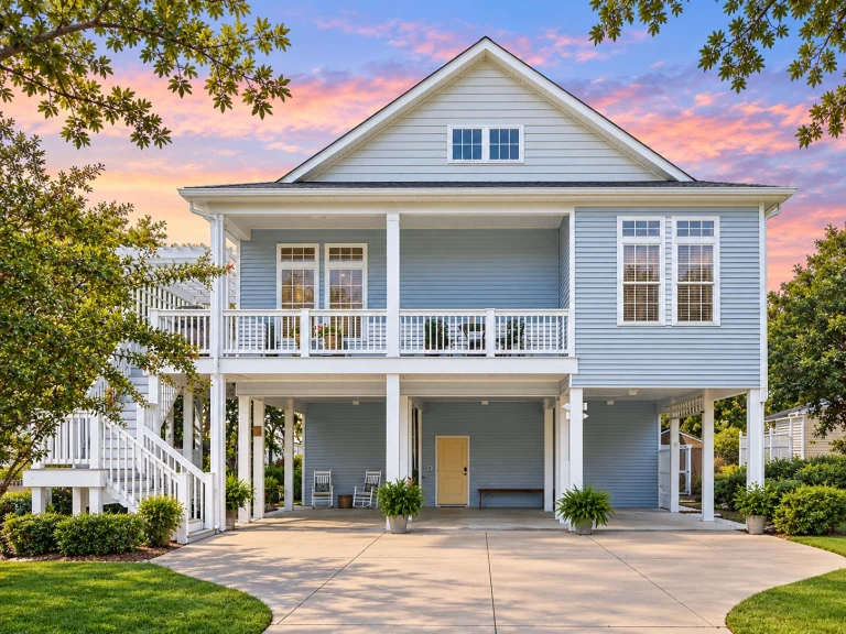 House Plans with Fireplace 21 Front view of a raised coastal beach house with light blue horizontal siding, elevated porch, and covered parking below