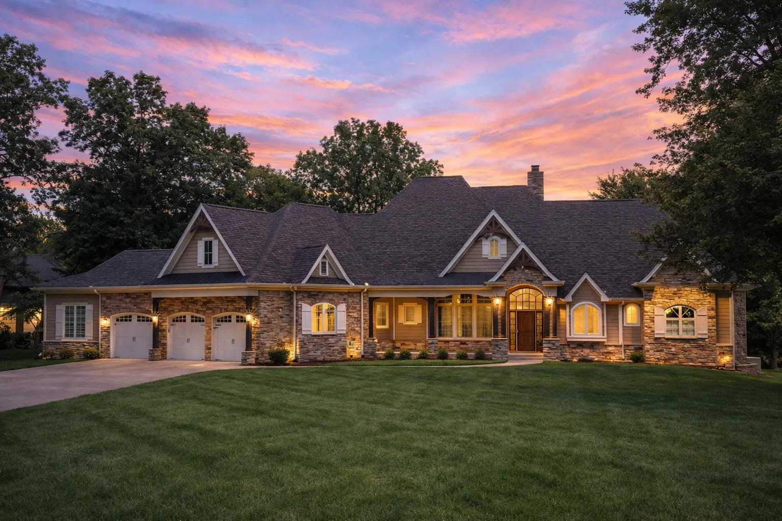 Front view of French Country European style home featuring a rich blend of brick and stone exterior, gabled rooflines, arched windows, and detailed wood accents
