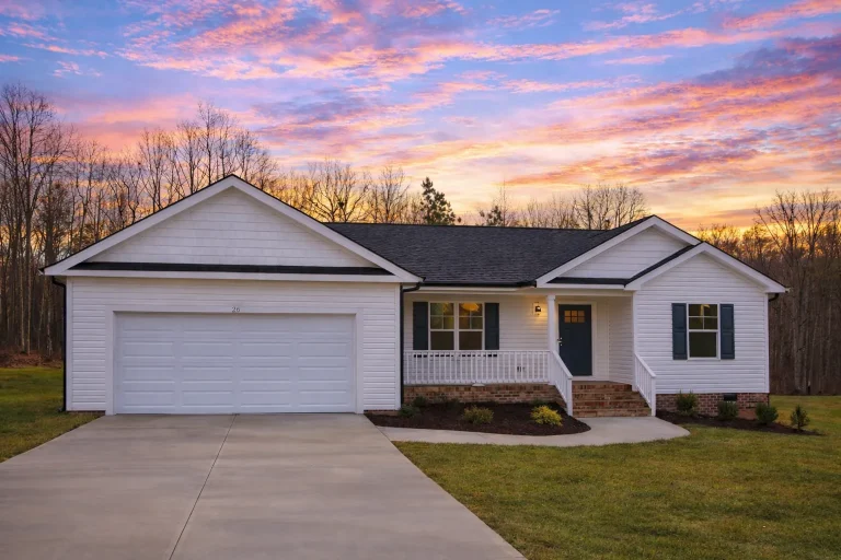 Front elevation of a Traditional Ranch Craftsman style home featuring blue horizontal siding, board and batten gables, white trim, and a brick foundation base with a front-entry garage