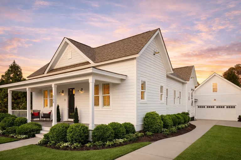 Front elevation of an American Cottage style house featuring Colonial Revival influences, horizontal siding, black shutters, and a welcoming covered porch