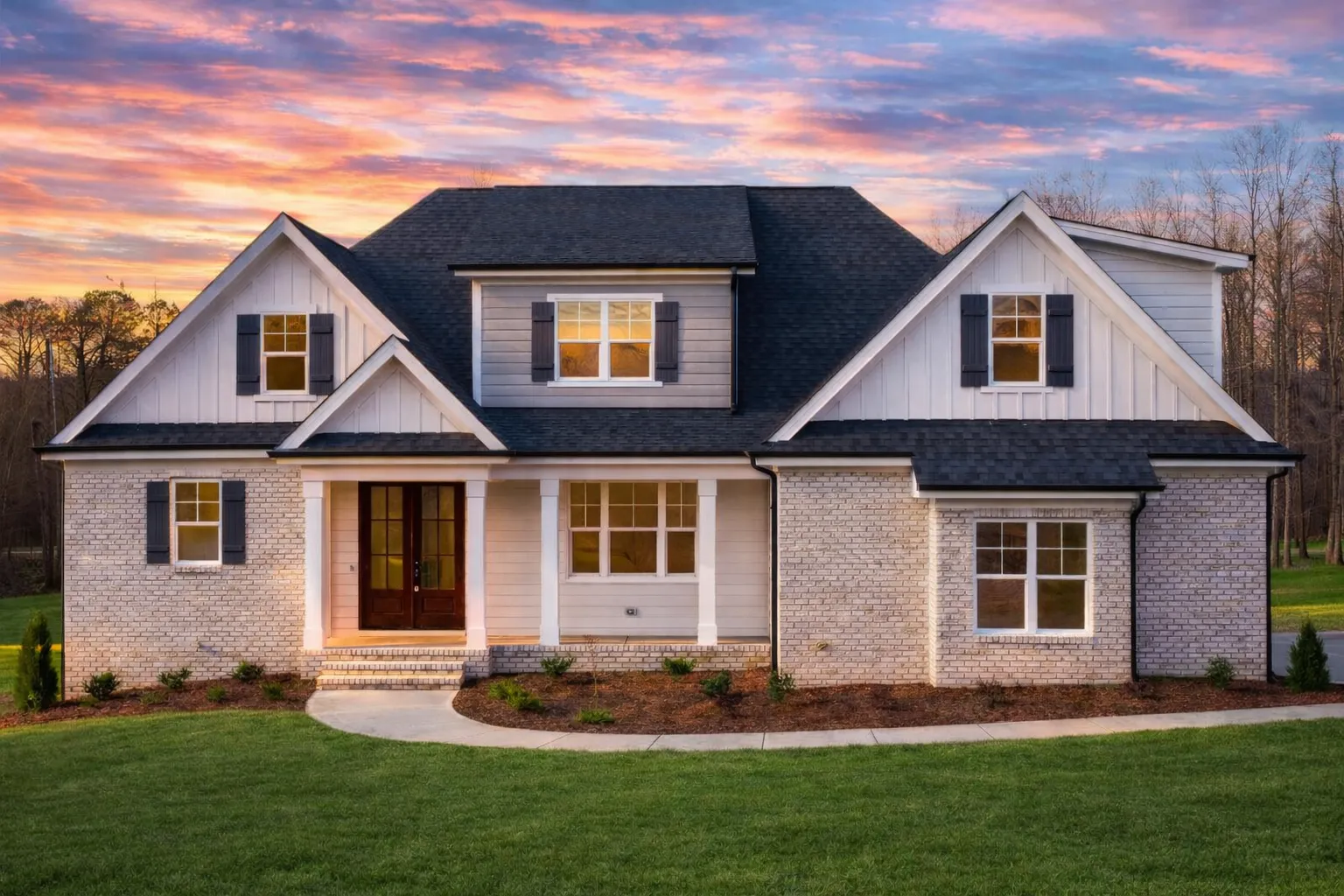 Front elevation of a New American style home with brick exterior, board and batten gables, symmetrical rooflines, and traditional suburban curb appeal